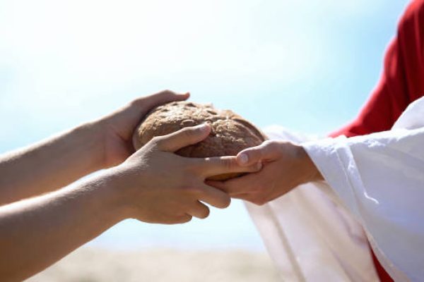 Jesus hands giving bread to poor man, biblical story to feed hungry, charity